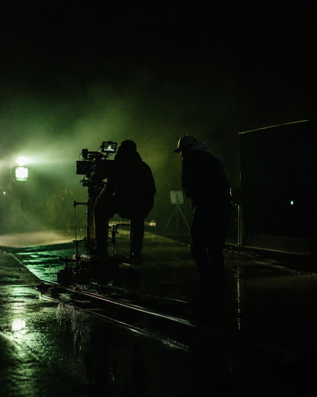 Film crew operating a camera dolly on a night set